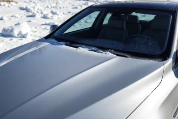 Visualizing PPF winter road salt protection on a sleek vehicle in a snowy setting.